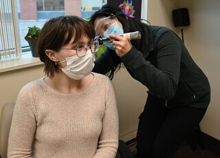 Audiologist and patient wearing a face mask